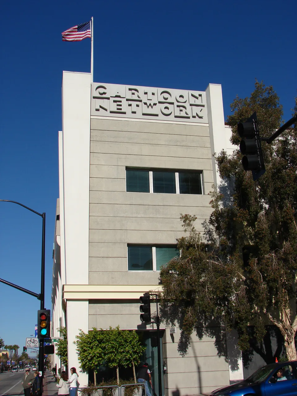 Tall cream-colored Cartoon Network Studios facade beneath a blue sky and U.S. flag.