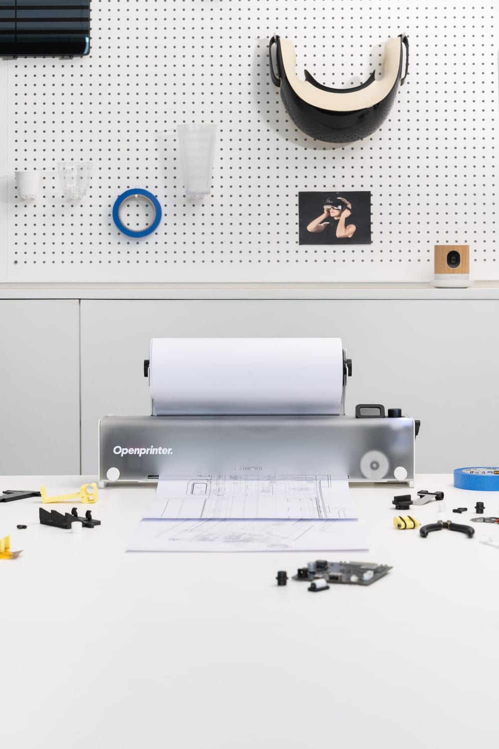 Openprinter on a desk beside a laptop, printing from a paper roll