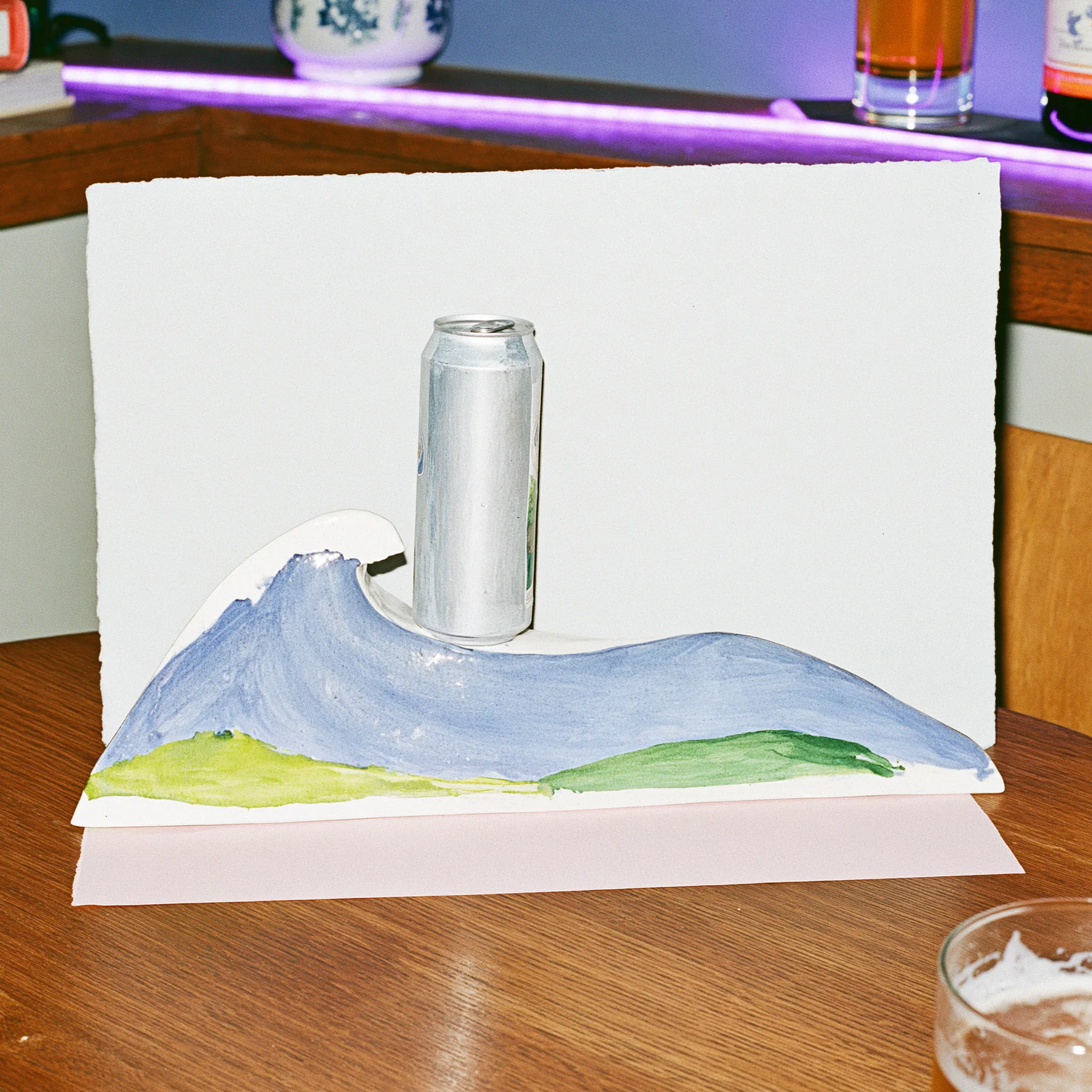 A pale paper-model wave pedestal displayed against a small backdrop